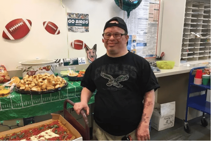 Doug Jarett, smiling, standing next to a table of snacks at a party.